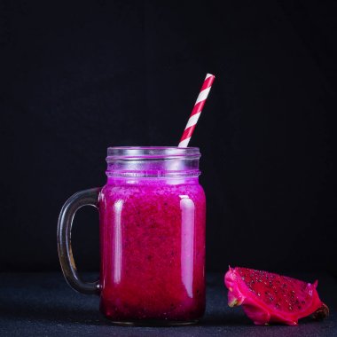 Dragon meyve, muz, mango ve papaya cam kupa siyah arka plan üzerine taze smoothies. Sağlıklı beslenme kavramı