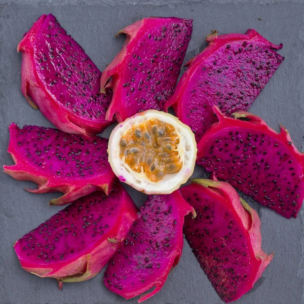 Exótica fruta de dragón rosa cortada y maracuyá en primer plano de fondo. Fruta tropical dulce, pitaya jugosa y fruta de la pasión cortada — Foto de Stock