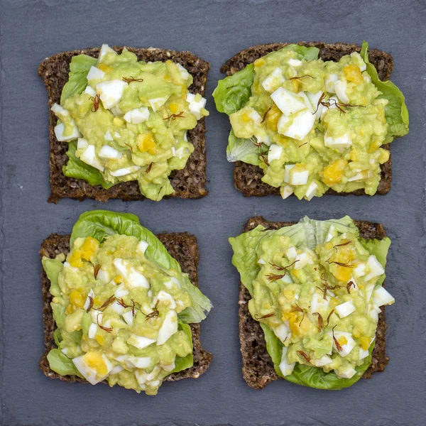 Sandwich con aguacate y huevo escalfado - concepto de desayuno saludable —  Fotos de Stock