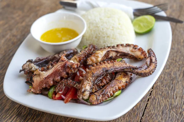 Smažené chobotnicové chapadla s bílou rýží na talíři, zblízka — Stock fotografie