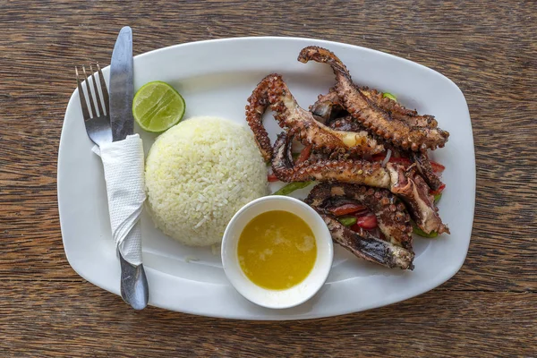 Tentacoli di polpo fritto con riso bianco su un piatto, da vicino — Foto Stock