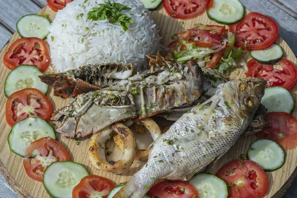白饭配海鲜和蔬菜,关门. 坦桑尼亚桑给巴尔岛上餐馆里的鱼、鱿鱼、虾、米、西红柿和黄瓜 — 图库照片
