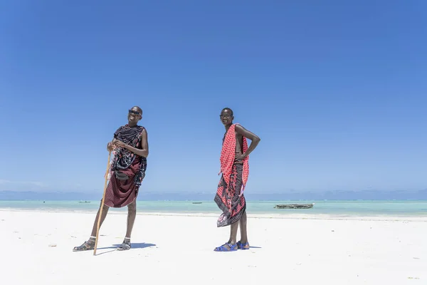 Afrikanische Masai-Männer in traditioneller Kleidung stehen in Meeresnähe am Sandstrand von Sansibar, Tansania — Stockfoto