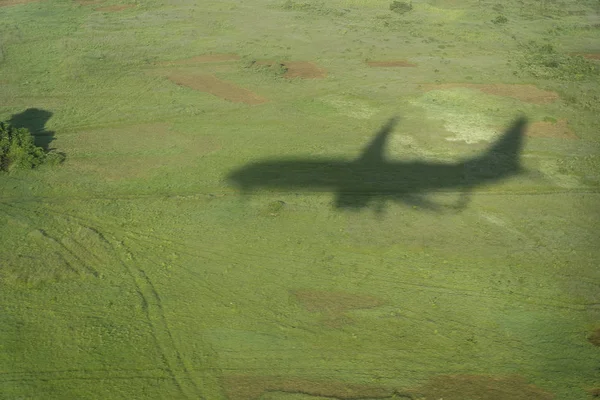 Sombra del avión en los campos verdes durante el aterrizaje — Foto de Stock