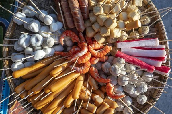 Gehaktballen en worstjes op stokjes in een kom met saus op de straatvoedselmarkt in Koh Phangan eiland, Thailand — Stockfoto