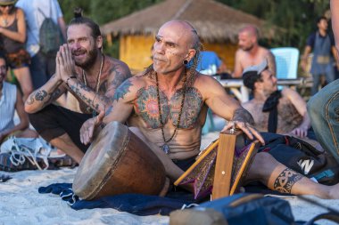 Street musicians playing on drum at sunset on beach at island Koh Phangan, Thailand