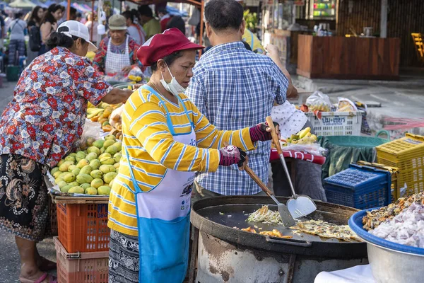 Mujer vendedora callejera tailandesa prepara y vende comida en el mercado callejero tradicional en la isla Koh Phangan, Tailandia — Foto de Stock