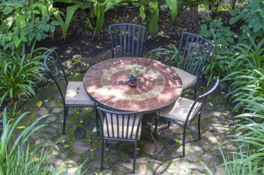 Empty restaurant terrace in tropical garden with tables and chairs. Tanzania, Africa