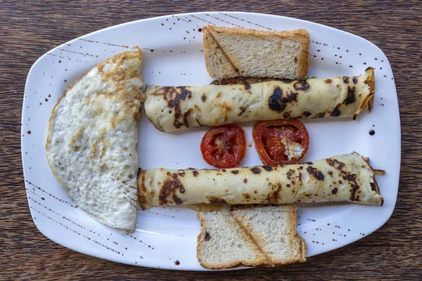 Petit déjeuner tropical d'œufs brouillés et de crêpes à la banane au restaurant de l'hôtel — Photo