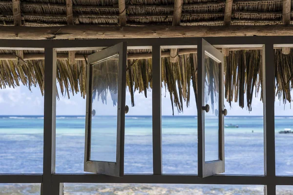 Open windows of thatched roof veranda overlooking the turquoise ocean on the island of Zanzibar, Tanzania, Africa — Stok fotoğraf