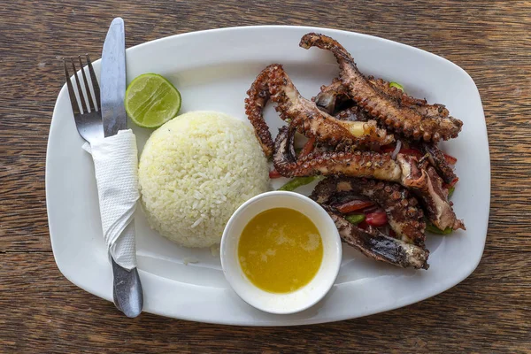 Tentacoli di polpo fritto con riso bianco su un piatto, da vicino — Foto Stock