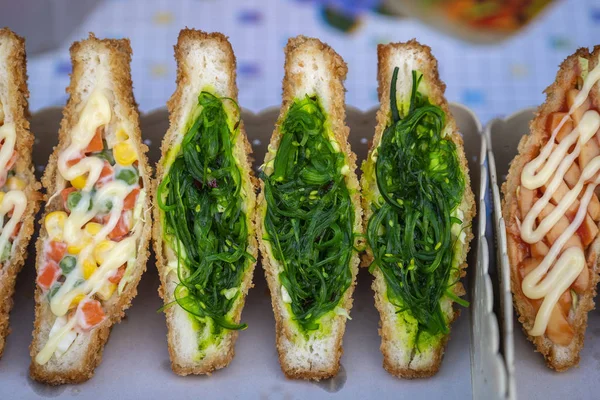 Sjögräs sallad smörgås till salu på street food marknaden i Thailand. Smaklig grön tång sallad smörgås närbild — Stockfoto