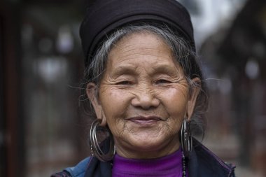 Sapa, Vietnam - Mart 02, 2020: Geleneksel kıyafet ve mücevher giyen etnik Hmong kadını, Sapa Bölgesi, Kuzey Vietnam 'da, sokakta el sanatları satmak için turistleri bekliyor