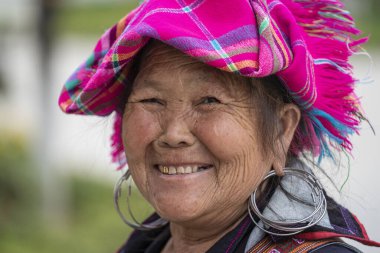 Sapa, Vietnam - Mart 02, 2020: Geleneksel kıyafet ve mücevher giyen etnik Hmong kadını, Sapa Bölgesi, Kuzey Vietnam 'da, sokakta el sanatları satmak için turistleri bekliyor