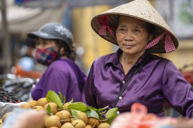Hanoi, Vietnam - Mart 01, 2020: Kadınlar Hanoi, Vietnam 'daki eski bir kasabanın sokak gıda pazarında meyve ve sebze satıyorlar