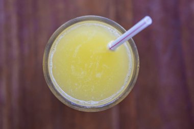 Bir bardak portakal suyu, ahşap arka planda saman içmek, üst manzara, kapat.