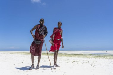 Zanzibar, Tanzanya - 11 Kasım 2019: Geleneksel kıyafetler giymiş iki Afrikalı adam okyanusun kıyısında, Zanzibar, Tanzanya