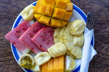 Kahvaltı tabağında tropik meyveler, yakın çekim. Taze karpuz, tutku meyvesi, ananas, Jackfruit, mango, papaya, plaj restoranında yemek için portakal, ada Zanzibar, Tanzanya, Afrika