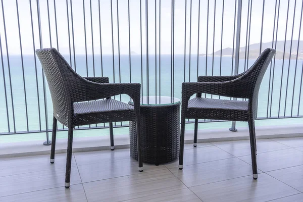 2つの籐製の椅子と ベトナムのNha Trangのリゾートタウンの海と熱帯のビーチの素晴らしい景色を望む高ホテルのバルコニーのテーブル 旅行と休暇のコンセプト — ストック写真
