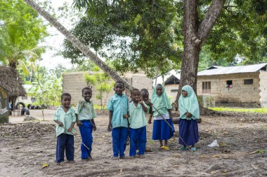 Zanzibar, Tanzanya - 30 Ekim 2019: Tanzanya, Doğu Afrika 'daki Zanzibar adasında dersten sonra yerel bir okulun yakınındaki kimliği belirsiz Afrikalı kız ve oğlanlar