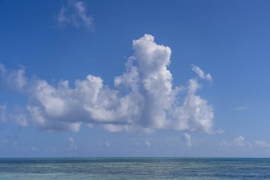 Doğu Afrika, Tanzanya 'daki Zanzibar adasındaki deniz suyu dalgaları üzerinde beyaz, güzel bulutlar ve mavi gökyüzü. Seyahat ve doğa kavramı