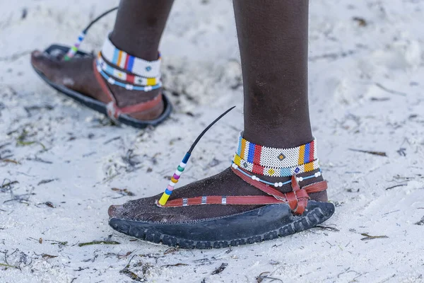 砂のビーチで車のタイヤで作られたカラフルなブレスレットとサンダルで部族のマサイの足を閉じます タンザニアのザンジバル島 東アフリカ — ストック写真