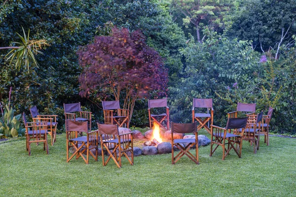 Etrafında Yanan Şenlik Ateşinin Manzarası Orman Yakınlarındaki Yeşil Çimlerde Sandalyeler — Stok fotoğraf
