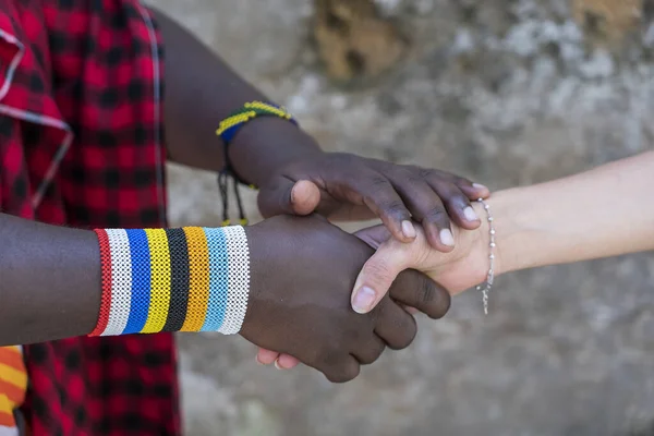 Masai tribal man with a caucasian girl making a handshake in the street on the island of Zanzibar, Tanzania, East Africa, close up