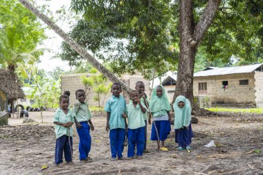 Zanzibar, Tanzanya - 30 Ekim 2019: Tanzanya, Doğu Afrika 'daki Zanzibar adasında dersten sonra yerel bir okulun yakınındaki kimliği belirsiz Afrikalı kız ve oğlanlar
