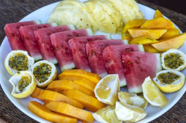 Kahvaltı tabağında tropik meyveler, yakın çekim, üst manzara. Taze karpuz, tutku meyvesi, ananas, mango, papaya, plaj restoranında yemek için portakal, ada Zanzibar, Tanzanya, Afrika