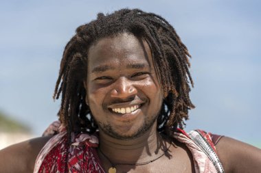 Zanzibar, Tanzanya - Ocak 04, 2020: Geleneksel kıyafetler giyen Afrikalı adam, Doğu Afrika 'nın Tanzanya kentindeki Zanzibar adasının sahilinde duruyor.