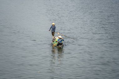 Hue, Vietnam - 12 Mart 2020: Hue şehrinde, Vietnam 'da iki Vietnamlı kadın kürek çekiyor.