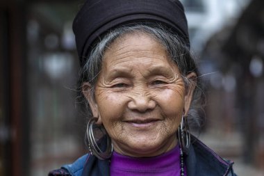 Sapa, Vietnam - Mart 02, 2020: Geleneksel kıyafet ve mücevher giyen etnik Hmong kadını, Sapa Bölgesi, Kuzey Vietnam 'da, sokakta el sanatları satmak için turistleri bekliyor