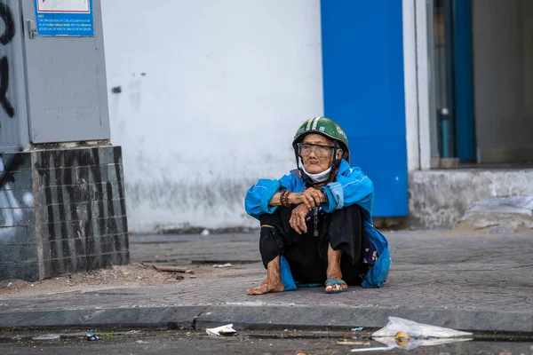 越南胡志明 2020年3月21日 越南胡志明市中心一条街道上的人行道上坐着戴着摩托车头盔的可怜的越南老妇人 — 图库照片