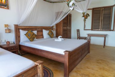 Lüks gösteriler için dekore edilmiş dört poster yataklı bir yazlık yatak odası. Doğu Afrika 'nın Zanzibar adasındaki tropikal villanın iç tasarımı