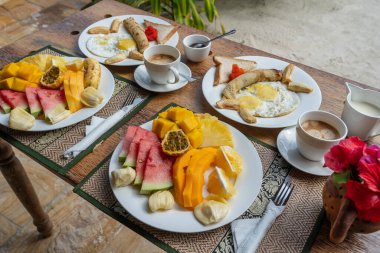 Otel restoranında, Zanzibar adasında, Tanzanya 'da, Afrika' da, deniz kenarındaki sahilde, meyveli, kahveli ve muzlu gözlemeli tropik kahvaltı.