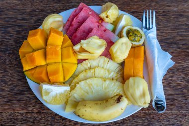 Kahvaltı tabağında tropik meyveler, yakın çekim. Taze karpuz, muz, tutku meyvesi, ananas, Jackfruit, mango, papaya, plaj restoranında yemek için portakal, ada Zanzibar, Tanzanya, Afrika