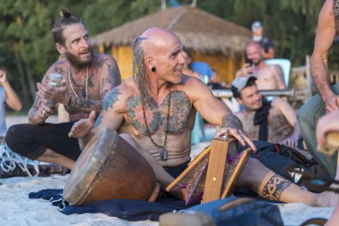 Koh Phangan, Tayland - 31 Ocak 2020: Sokak müzisyenleri gün batımında Tayland 'ın Koh Phangan adasında deniz kenarında turistler için davul çalıyorlar