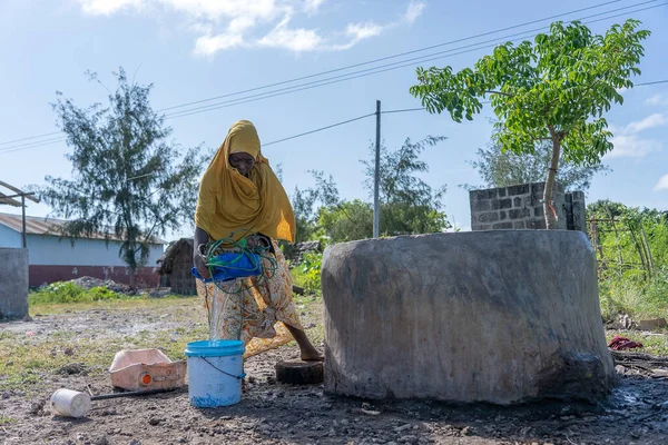 坦桑尼亚桑给巴尔 2020年1月14日 在坦桑尼亚桑给巴尔岛的一条街上 一名身份不明的非洲女孩和一个装有水的桶 — 图库照片