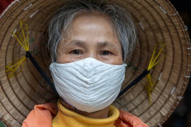 Sapa, Vietnam - march 06, 2020 : Ethnic Hmong old woman with protective mask on the face on a street of Sapa, North Vietnam