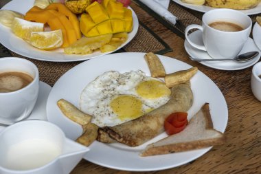 Otel restoranında, Zanzibar adasında, Tanzanya 'da, Afrika' da, deniz kenarındaki sahilde, meyveli, kahveli ve muzlu gözlemeli tropik kahvaltı.