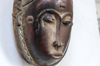 African mask on a stone wall background, Tanzania, east Africa. Close up