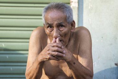 Ho Chi Minh, Vietnam - 21 Mart 2020: Zavallı Vietnamlı adam Ho Chi Minh şehrinde bir kaldırımda oturuyor, Vietnam