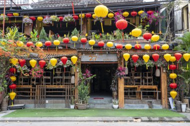 Hoi An, Vietnam - 15 Mart 2020 Hoi An nehrinin yanında renkli kırmızı ve sarı lambalı sokak restoranı. Hoi An, Vietnam 'ın ortasında Danang yakınlarında bir şehirdir ve iyi korunmuş eski kasabasıyla ünlüdür.