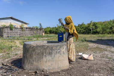 Zanzibar, Tanzanya - 14 Ocak 2020: Tanzanya, Doğu Afrika 'daki Zanzibar Adası' nda bir sokakta tanımlanamayan Afrikalı kız ve kova