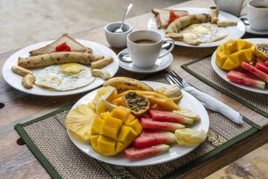 Otel restoranı, Zanzibar adası, Tanzanya, Afrika 'da deniz kenarındaki plajda iki kişilik meyve, kahve ve muzlu krep. Üst görünüm, tablo ayarı.