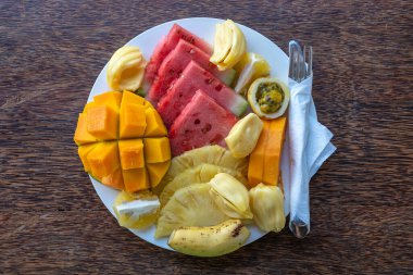 Kahvaltı tabağında tropik meyveler, yakın çekim, üst manzara. Taze karpuz, tutku meyvesi, ananas, mango, papaya, plaj restoranında yemek için portakal, ada Zanzibar, Tanzanya, Afrika