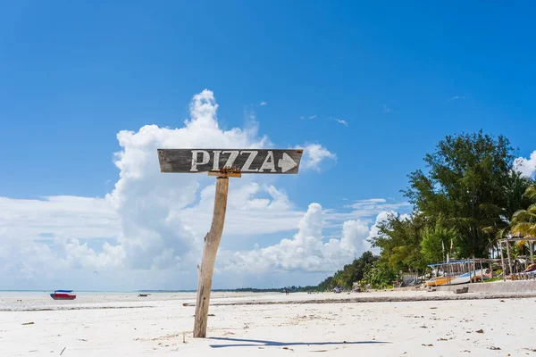 坦桑尼亚桑给巴尔岛上热带沙滩上的一个木柱上的尖披萨 旅行和休假概念 — 图库照片