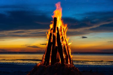 Büyük yangın, Tanzanya, Doğu Afrika 'daki Zanzibar adasında, deniz kenarında gece gökyüzünün arka planına karşı yanar. Parlak alev. Akşamları şenlik ateşi.