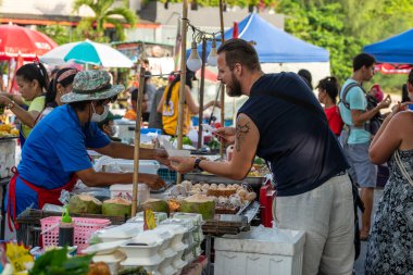 Koh Phangan, Tayland - 08 Şubat 2020: Tayland sokak satıcısı Koh Phangan, Tayland 'daki geleneksel sokak pazarında yiyecek hazırlıyor ve satıyor